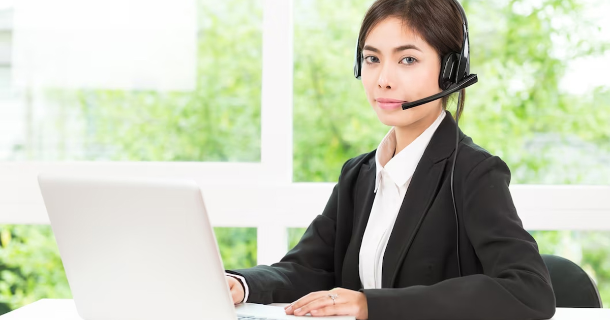 Hình ảnh nhân viên hỗ trợ khách hàng thân thiện đang tương tác qua máy tính, biểu thị dịch vụ 24/7 chuyên nghiệp.